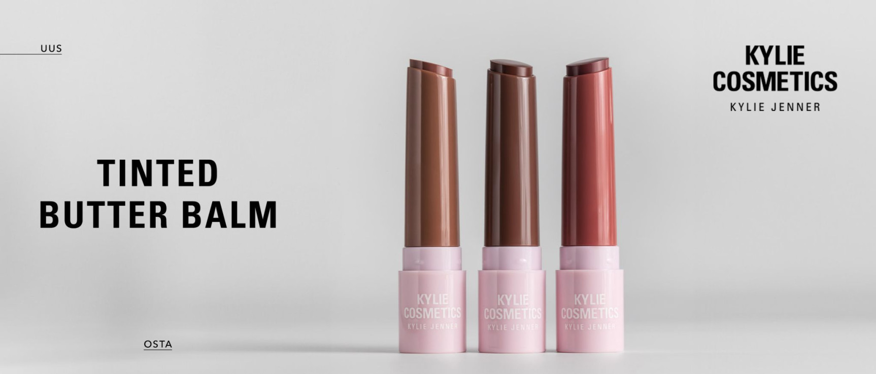Kolm KYLIE COSMETICS by Kylie Jenner toonivat huulevõid roosas pakendis valgel taustal, erinevates nude-toonides. Pealdises on tekst "TINTED BUTTER BALM".
