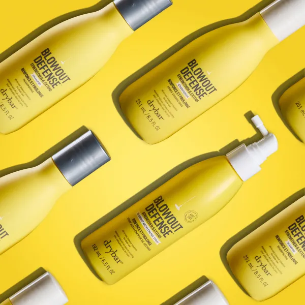 Drybar Blowout Defense juuksehooldustoodete kollektsioon kollasel taustal.