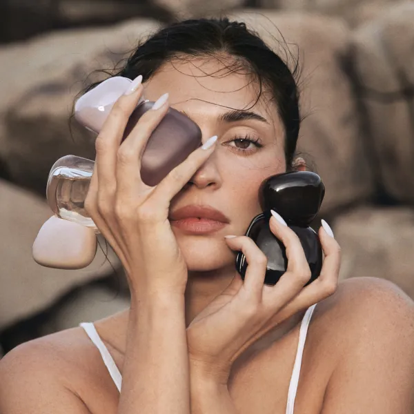 Inimene hoiab käes mitut Kylie Fragrances Mood Stones parfüümipudelit kivisel taustal.